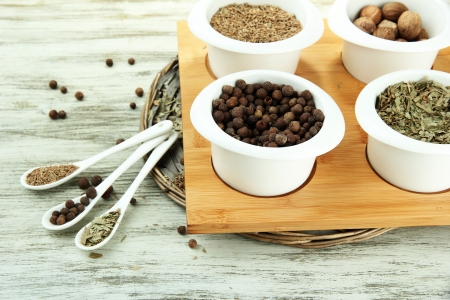 Assortment of spices in  white spoons and bowls, on wooden backgroundの写真素材