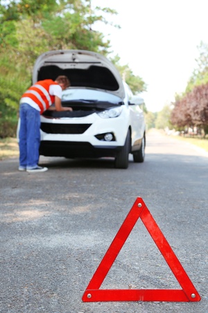 Broken down car with red warning triangleの写真素材