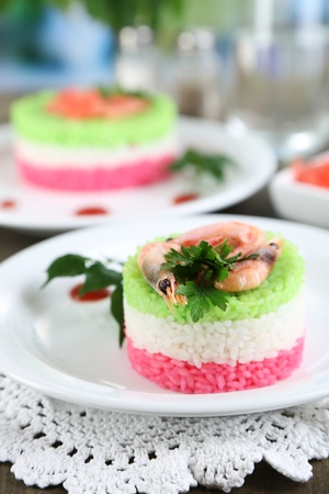 Colored rice on plates on napkin on wooden table on room backgroundの写真素材