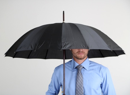 Businessman with umbrella. on gray backgroundの写真素材
