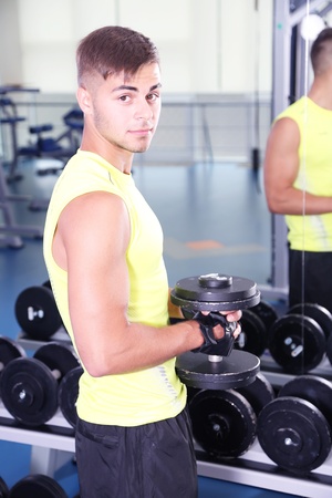 Guy with dumbbells in gymの写真素材