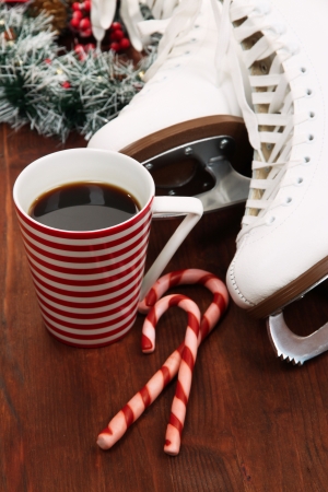 Figure skates with cup of coffee on table close-upの写真素材