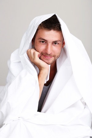 Handsome young man in bedの写真素材