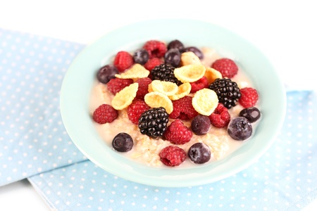 Oatmeal in bowl with berries isolated on whiteの写真素材