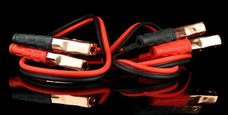 Car battery jumper cables on black background