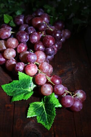 Ripe purple grapes on wooden table close-up の写真素材