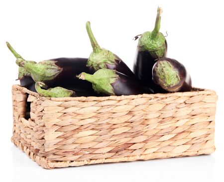Fresh eggplants in wicker basket isolated on whiteの写真素材