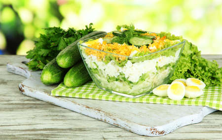Delicious salad with eggs, cabbage and cucumbers on wooden tableの写真素材