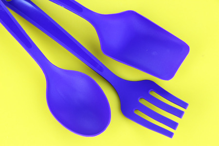 Plastic kitchen utensils on yellow backgroundの写真素材