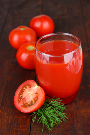 Tomato juice in glass, on wooden backgroundの写真素材