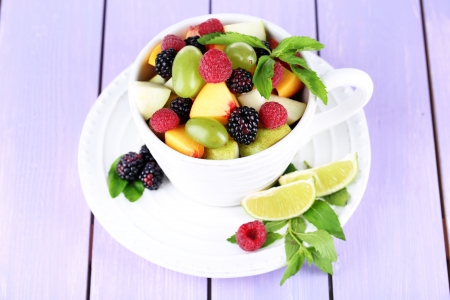 Fruit salad in cup on wooden tableの写真素材