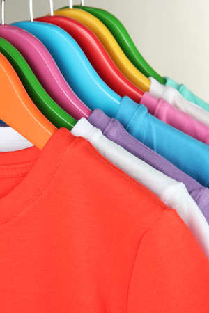 Different shirts on colorful hangers on grey backgroundの写真素材