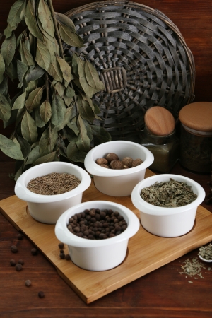 Assortment of spices in  white spoons and bowls, on wooden backgroundの写真素材