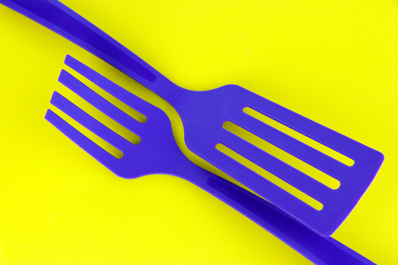 Plastic kitchen utensils on yellow backgroundの写真素材