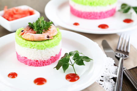 Colored rice on plates on napkins on wooden tableの写真素材