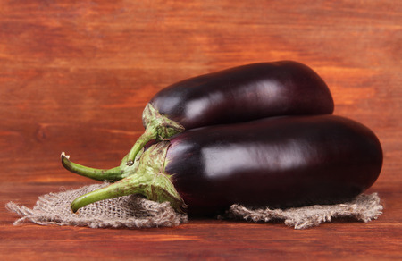 Fresh eggplants on table on wooden backgroundの写真素材