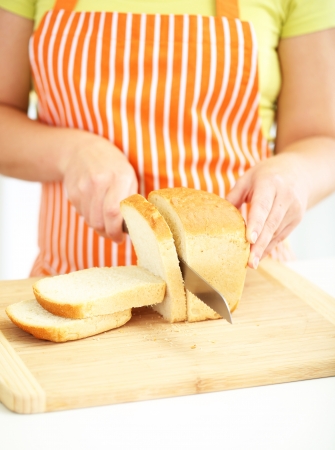 Woman slicing bread on chopping board, close up