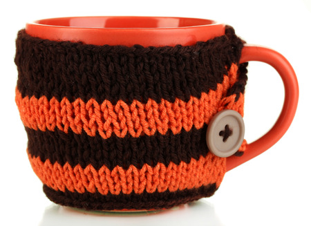 Cup with knitted thing on it isolated on whiteの写真素材