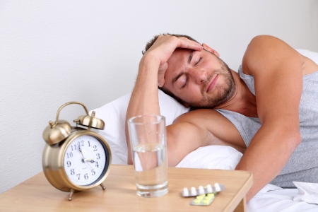 Handsome young man in bedの写真素材