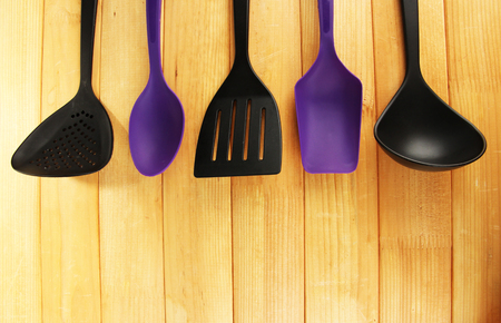 Plastic kitchen utensils on wooden backgroundの写真素材