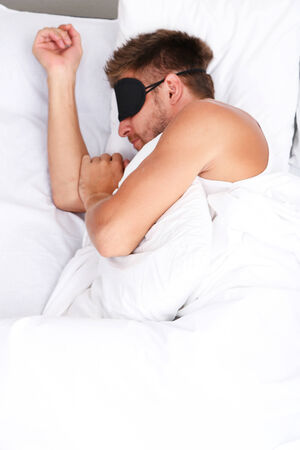 Handsome young man in bedの写真素材