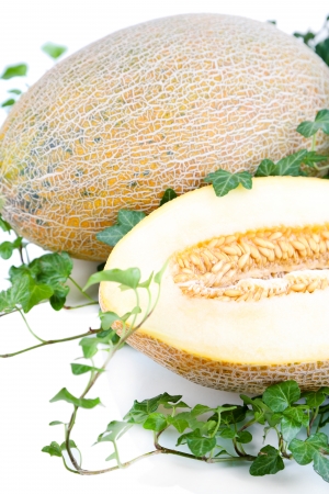 Ripe melons in leaves isolated on whiteの写真素材