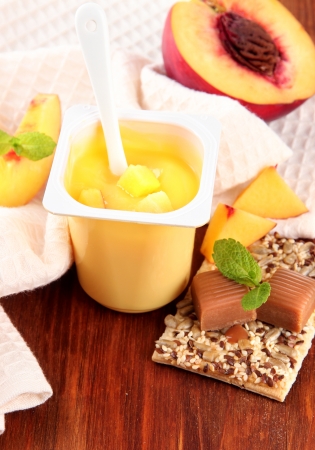 Tasty yogurt with pieces of fresh fruits, cookies and flakes,on wooden backgroundの写真素材