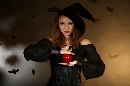 Halloween witch with apple on dark backgroundの写真素材