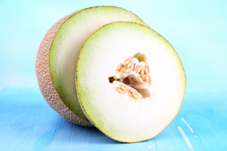 Ripe melons on wooden table on blue の写真素材