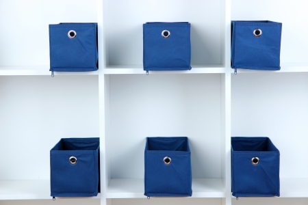 Blue textile boxes in white shelves の写真素材