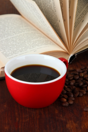 Cup of coffee with coffee beans and book on wooden backgroundの写真素材