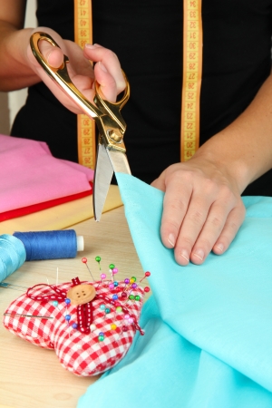 Cutting fabric with tailors scissors の写真素材