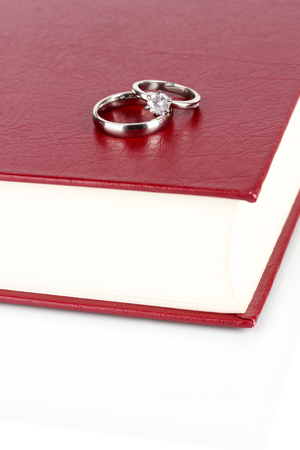 Wedding rings on bible isolated on whiteの写真素材
