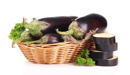 Fresh eggplants in wicker basket isolated on whiteの写真素材