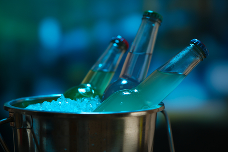Bottled drinks in ice bucket on bright backgroundの写真素材