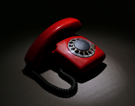 Red retro telephone on dark color backgroundの写真素材