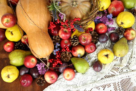 Autumn composition of fruits, pumpkins and flowers on table close-up