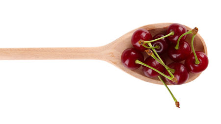 Cherry in wooden spoon isolated on white の写真素材