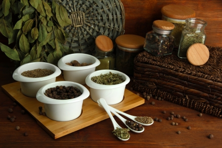 Assortment of spices in  white spoons and bowls, on wooden の写真素材