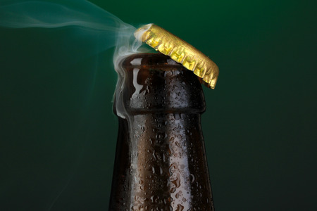 Top of open wet beer bottle on dark の写真素材