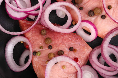 A pieces of pork with onions fried in pan close-upの写真素材
