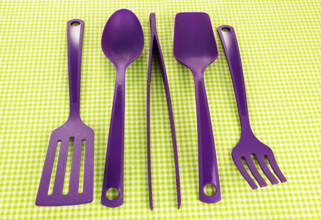 Plastic kitchen utensils on fabric backgroundの写真素材