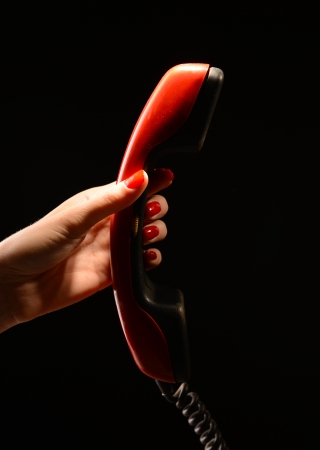 Receiver in female hand,on dark backgroundの写真素材