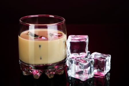Baileys liqueur in glass on pink backgroundの写真素材