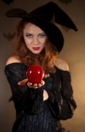 Halloween witch with apple on dark backgroundの写真素材