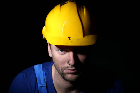 Portrait of young worker on dark background