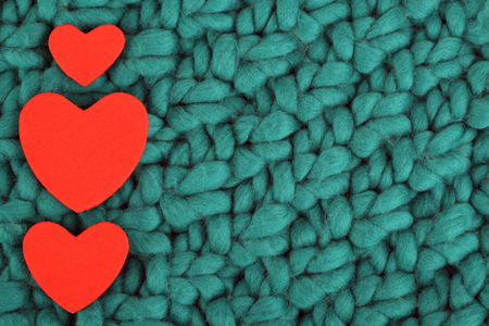 Hearts made of felt on green knitted backgroundの写真素材