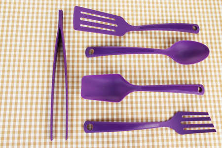 Plastic kitchen utensils on fabric backgroundの写真素材