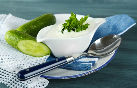 Cucumber yogurt in sauceboat, on color napkin, oncolor wooden  backgroundの写真素材