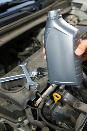 Auto mechanic hand holding motor oil の写真素材